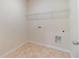 A simple laundry room features tile flooring and utility hookups at 1821 Silver Crest Way, Hoschton, GA 30548