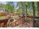 View of the backyard area with a wooden fence and mature trees, as seen from the wooden deck at 365 Falling Timber Ct, Stockbridge, GA 30281