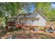 Backyard featuring a wood deck, trees, and a home with white siding at 365 Falling Timber Ct, Stockbridge, GA 30281