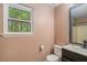 Small bathroom with a single vanity, toilet, and view of nature outside the window at 365 Falling Timber Ct, Stockbridge, GA 30281