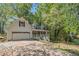 Charming two-story home with a front porch, attached garage, and mature trees on a sunny day at 365 Falling Timber Ct, Stockbridge, GA 30281