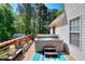 Relax on the wooden deck with a hot tub overlooking lush greenery for a private outdoor oasis at 377 Lakeview Dr, Newborn, GA 30056