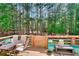 Enjoy outdoor dining on the spacious wooden deck with a table and chairs surrounded by trees at 377 Lakeview Dr, Newborn, GA 30056