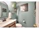 Stylish powder room with decorative mirror, wood vanity and neutral color scheme at 377 Lakeview Dr, Newborn, GA 30056