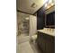 Well-lit bathroom with marble tiled shower, dark wood paneled wall, and modern fixtures at 760 Whitehall Way, Roswell, GA 30076