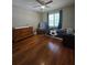 Well-lit bedroom with hardwood floors, a comfy chair, and ample storage options at 760 Whitehall Way, Roswell, GA 30076