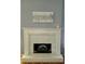 Close-up of a fireplace with a mantel, stone surround, and decorative art at 760 Whitehall Way, Roswell, GA 30076