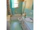 Small, dated bathroom with blue tile, a tub and shower combo, and an outdated toilet and sink at 811 Verde Dr, Riverdale, GA 30274