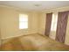 Bedroom with yellow walls, carpeted floors, and natural light from the windows at 811 Verde Dr, Riverdale, GA 30274