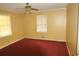 Bedroom with yellow walls, red carpeting, ceiling fan, and natural light from the windows at 811 Verde Dr, Riverdale, GA 30274