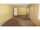 Spacious living room with yellow walls, carpeted floors, and natural light from multiple windows at 811 Verde Dr, Riverdale, GA 30274