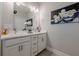 Modern bathroom featuring dual sinks, white cabinets, and decorative wall art at 3877 Via Cima Ln, Suwanee, GA 30024