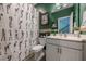Fun guest bath features golf-themed shower curtain, golf decor, white vanity, and a green painted wall at 3877 Via Cima Ln, Suwanee, GA 30024