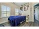 Cozy bedroom featuring wood floors, two windows, and unique decor with pictures and artistic accents at 3877 Via Cima Ln, Suwanee, GA 30024