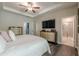 A bedroom showing a view into the en suite bathroom and the entertainment center at 3877 Via Cima Ln, Suwanee, GA 30024