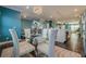 Dining area with glass table, white chairs, views to the stairway, island kitchen, and living area at 3877 Via Cima Ln, Suwanee, GA 30024