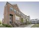 Brick townhomes showing balconies, sidewalks, and manicured landscaping at 3877 Via Cima Ln, Suwanee, GA 30024
