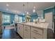Bright kitchen featuring a large island with white countertop, pendant lighting, and stainless steel appliances at 3877 Via Cima Ln, Suwanee, GA 30024