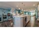 Kitchen with white cabinets, stainless appliances, quartz countertops, and view to the stairway and open living areas at 3877 Via Cima Ln, Suwanee, GA 30024