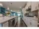 Open concept kitchen with white cabinets, quartz countertops, stainless appliances, and views to the living room at 3877 Via Cima Ln, Suwanee, GA 30024