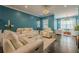 This is a living room with white furniture, hardwood floors, and many windows for great light at 3877 Via Cima Ln, Suwanee, GA 30024