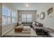A living room with decorative wall art, a large window, and leather furniture at 3877 Via Cima Ln, Suwanee, GA 30024