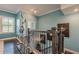 Stairway with a modern chrome and glass table, wood stairs, iron railing, and blue walls at 3877 Via Cima Ln, Suwanee, GA 30024