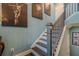 The stairway boasts blue walls and modern artwork, leading to a bright upper level at 3877 Via Cima Ln, Suwanee, GA 30024
