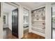 Hallway featuring a charming black door leading to a bedroom, complemented by built-in shelving and hardwood floors at 391 Collier Nw Rd, Atlanta, GA 30309