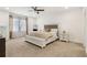 Spacious bedroom with carpet, ceiling fan, and a large bed with tufted headboard and a bench at the foot at 605 Stone Field Nw Run, Marietta, GA 30060