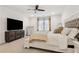 Well-lit bedroom with large TV, ceiling fan, and carpeted floors for maximum comfort at 605 Stone Field Nw Run, Marietta, GA 30060