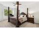Bedroom featuring a decorative 4-poster bed, large window and traditional lamps and nightstand furniture at 605 Stone Field Nw Run, Marietta, GA 30060