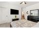 Bedroom featuring a large TV, ceiling fan, dresser, and a comfortable bed with patterned bedding at 605 Stone Field Nw Run, Marietta, GA 30060