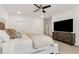 Bright bedroom featuring a ceiling fan, television, and a comfortable king-sized bed with decorative pillows at 605 Stone Field Nw Run, Marietta, GA 30060