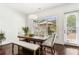 Bright dining area with a wooden table, bench seating, a stylish light fixture, and access to the outside at 605 Stone Field Nw Run, Marietta, GA 30060