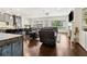 Living room view featuring a gray sectional sofa, dark wood floors, and kitchen breakfast bar at 605 Stone Field Nw Run, Marietta, GA 30060