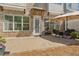 View of the patio with pavers, seating and umbrella, with brick exterior and awning at 605 Stone Field Nw Run, Marietta, GA 30060