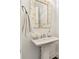 Stylish powder room featuring a pedestal sink, decorative mirror, and elegant finishes at 605 Stone Field Nw Run, Marietta, GA 30060