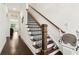 Staircase with a wood railing and a chairlift for accessibility, next to a living area with hardwood flooring at 605 Stone Field Nw Run, Marietta, GA 30060