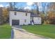 Beautifully renovated house with a well-maintained lawn and a driveway leading to the garage at 9148 Homewood Dr, Riverdale, GA 30274