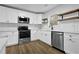 Bright kitchen featuring stainless steel appliances, white cabinetry and floating wood shelves at 9148 Homewood Dr, Riverdale, GA 30274