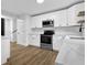 Kitchen boasts white cabinets, stainless steel appliances, and quartz countertops at 9148 Homewood Dr, Riverdale, GA 30274