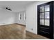 Bright living room with hardwood floors, a modern ceiling fan, and a stylish black front door at 9148 Homewood Dr, Riverdale, GA 30274