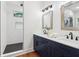 Bathroom features a dual sink vanity with chrome fixtures, bright lighting, and a glass shower at 1596 Pontiac Se Pl, Atlanta, GA 30315