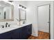 Bathroom features a dual sink vanity with chrome fixtures, bright lighting, and wood flooring at 1596 Pontiac Se Pl, Atlanta, GA 30315