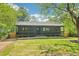 Inviting home with a covered porch, lush green lawn, and mature trees providing shade at 1596 Pontiac Se Pl, Atlanta, GA 30315