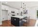 Modern kitchen with white cabinets, a dark island, quartz countertops, and stainless steel appliances at 1596 Pontiac Se Pl, Atlanta, GA 30315