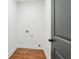 Cozy laundry room with wood floors, light walls, and a gray door at 1596 Pontiac Se Pl, Atlanta, GA 30315