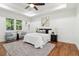 Bright main bedroom with wood floors, ceiling fan, tray ceiling, sitting area, and abundant natural light at 1596 Pontiac Se Pl, Atlanta, GA 30315