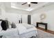 Bright main bedroom with wood floors, ceiling fan, tray ceiling, and console table at 1596 Pontiac Se Pl, Atlanta, GA 30315